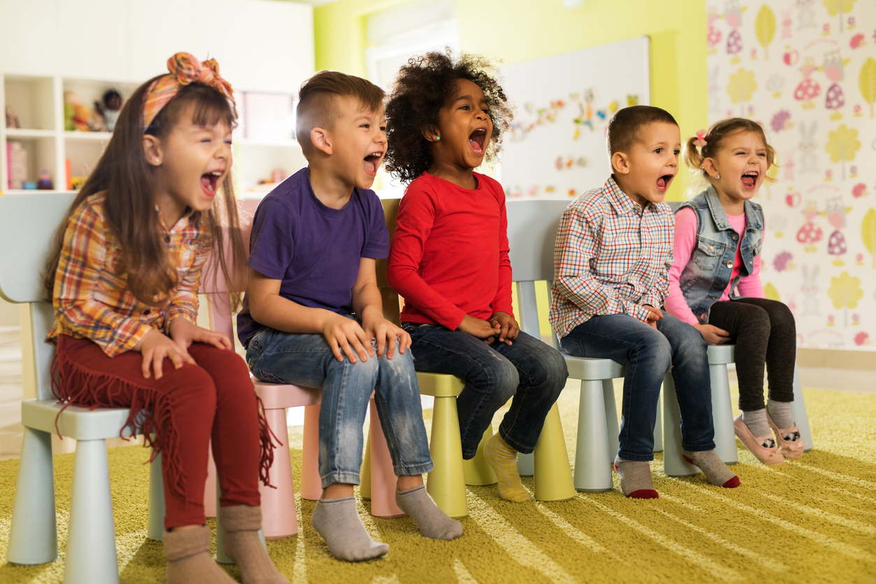 Group of mischief kids sitting at preschool and screaming.
